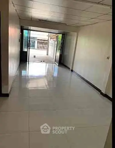 Spacious empty room with large windows and tiled flooring, ideal for customization.