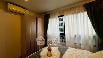 Cozy bedroom with natural light, modern wardrobe, and air conditioning, perfect for relaxation.