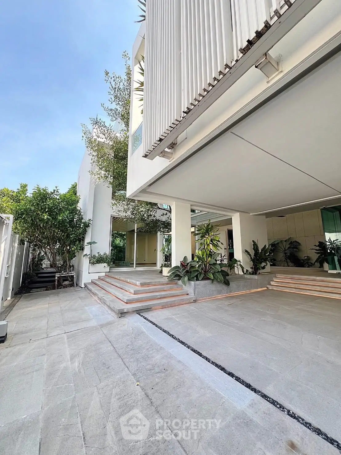 Modern architectural entrance with sleek design and lush greenery