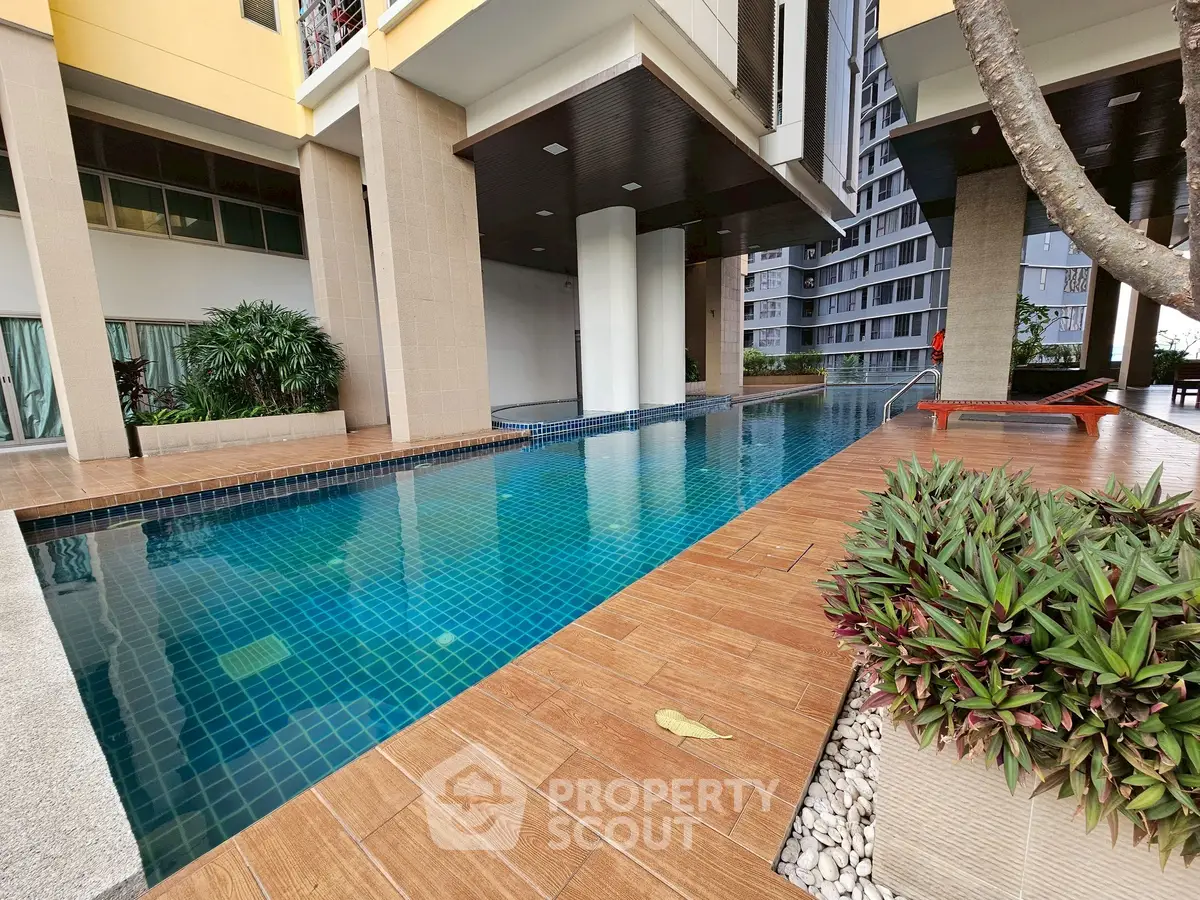 Luxurious condominium pool area with modern design and lush greenery.