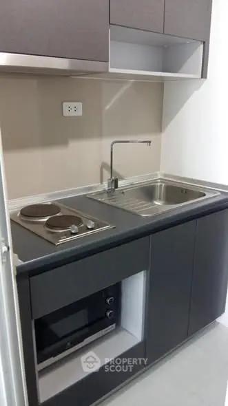 Modern compact kitchen with sleek cabinetry and built-in appliances.