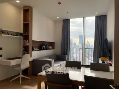 Modern living room with city view, featuring sleek furniture and floor-to-ceiling windows.