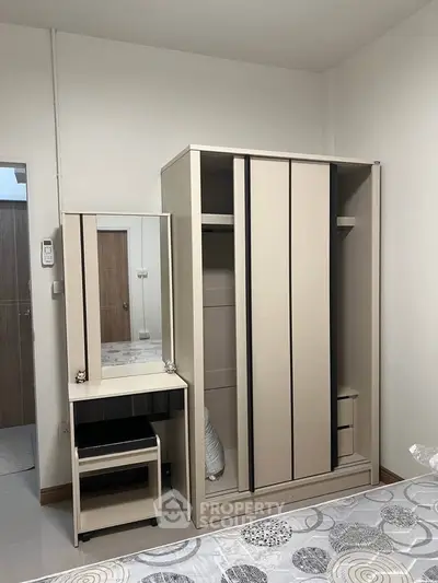 Cozy bedroom with modern wardrobe and dressing table, perfect for stylish living.