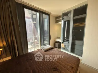 Luxurious bedroom with floor-to-ceiling windows and balcony access in modern apartment.