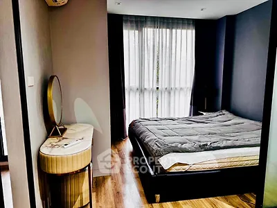 Modern bedroom with stylish decor and large window for natural light.