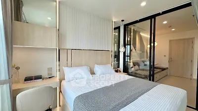 Modern bedroom with stylish decor and natural light, featuring a cozy bed and elegant furnishings.