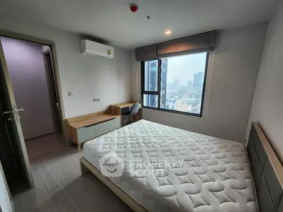 Modern bedroom with city view, featuring a comfortable bed and stylish furniture.