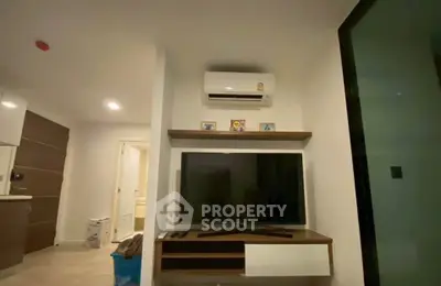 Modern living room with sleek TV setup and air conditioning in a cozy apartment.