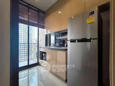 Modern kitchen with sleek cabinets and stainless steel fridge, featuring a balcony view in a high-rise apartment.
