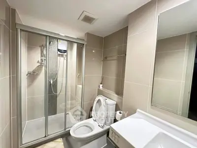 Modern bathroom with glass shower and sleek fixtures in contemporary apartment.