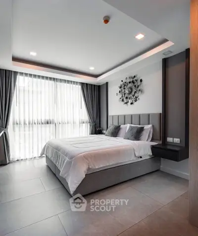 Modern bedroom with stylish decor and large window for natural light