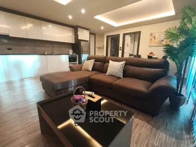 Spacious modern living room with sleek kitchen, cozy sectional sofa, and elegant decor in open layout apartment.
