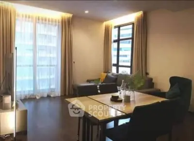Spacious living room with elegant decor and large windows in modern apartment.