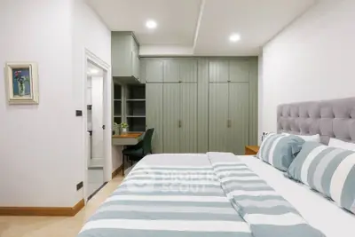 Modern bedroom with stylish green wardrobes and cozy bed setup