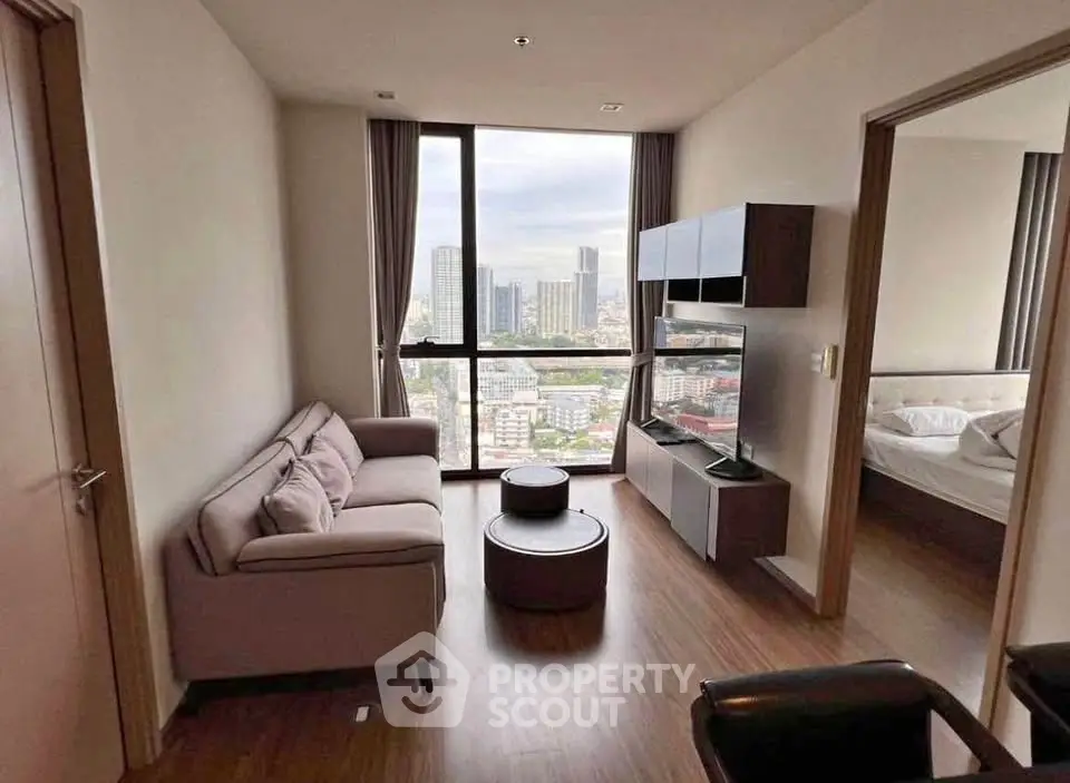 Modern living room with city view, stylish furniture, and large windows in a high-rise apartment.