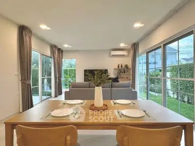 Spacious living room with modern decor and garden view, perfect for family gatherings.