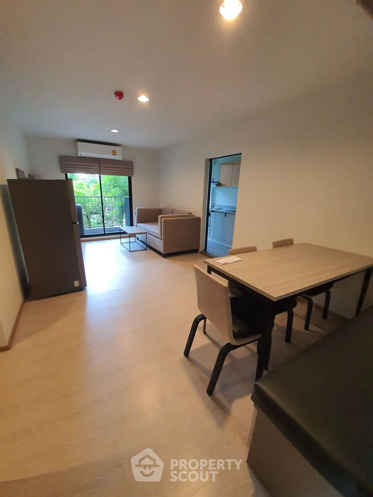 Spacious living room with modern furniture and balcony view in a stylish apartment.