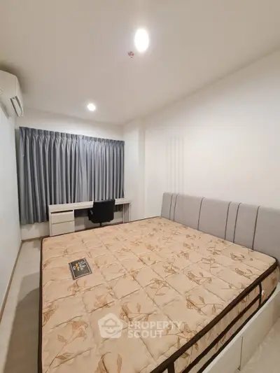 Spacious bedroom with large bed and study desk, perfect for comfort and productivity.