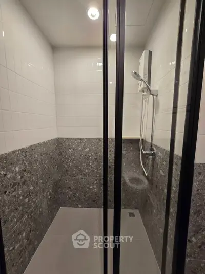 Modern shower area with sleek glass doors and contemporary tile design