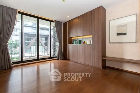 Spacious modern living room with large windows and elegant wooden flooring.