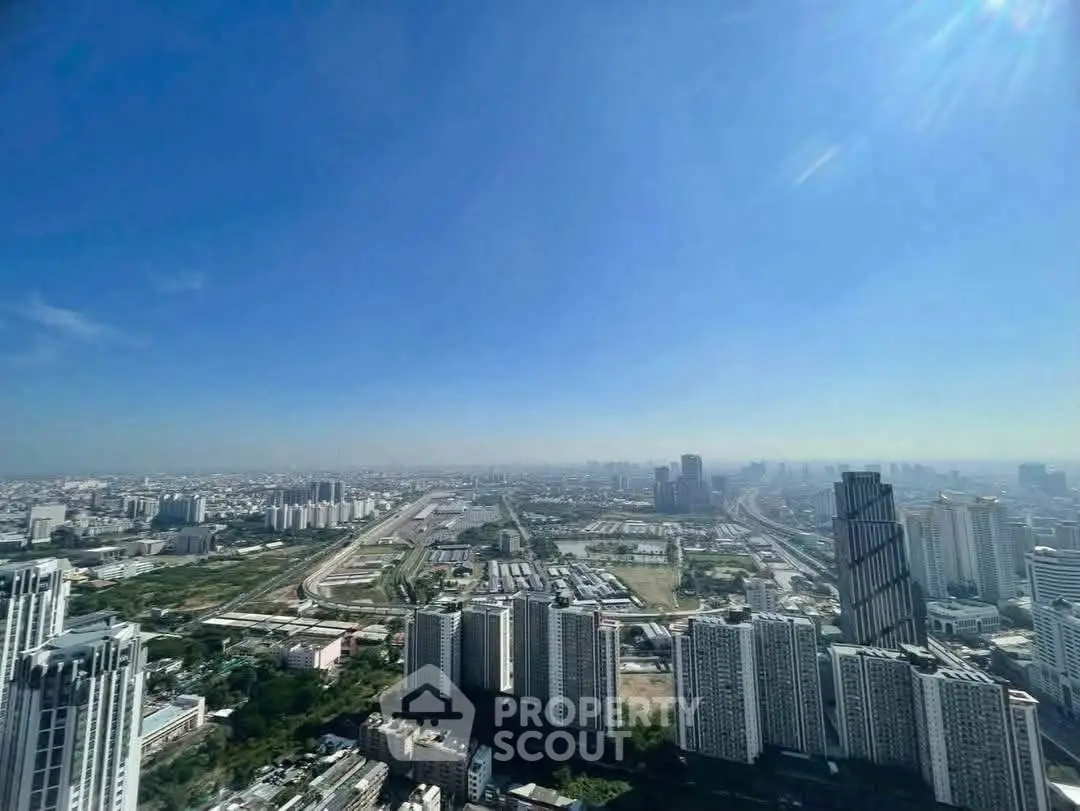 Stunning panoramic cityscape view from a high-rise building, showcasing urban skyline and clear blue sky.
