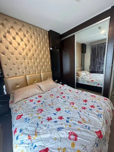 Luxurious bedroom with tufted headboard and mirrored wardrobe in modern apartment.