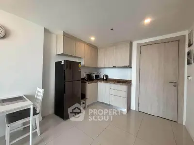 Modern kitchen with sleek cabinetry and stainless steel appliances in a cozy apartment setting.
