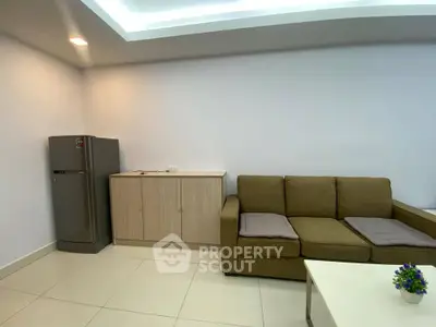 Modern living room with sleek fridge and cozy sofa in minimalist design.