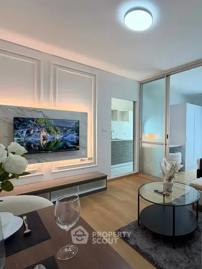 Modern living room with stylish decor and open layout, featuring a sleek TV setup and elegant furnishings.