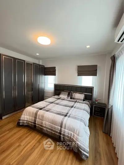 Modern bedroom with stylish decor and ample natural light