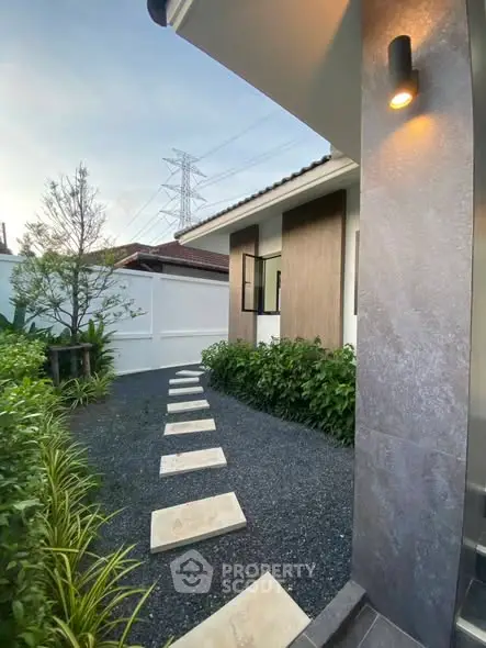 Charming modern home exterior with landscaped garden and pathway, perfect for serene living.