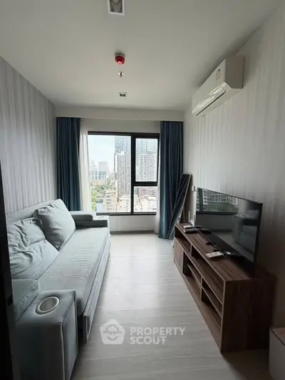 Modern living room with city view, featuring a cozy sofa and sleek entertainment unit.