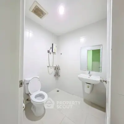 Modern bathroom with sleek white tiles and contemporary fixtures in a minimalist design.