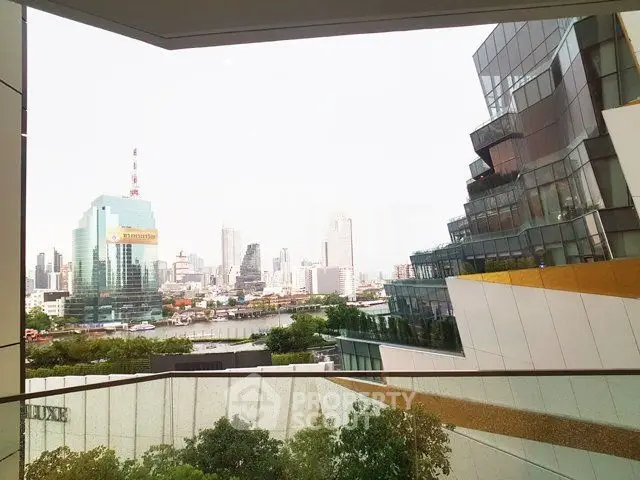 Stunning cityscape view from modern building balcony with glass railing.