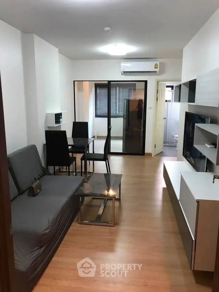 Modern living room with sleek furniture and wooden flooring in a stylish apartment.