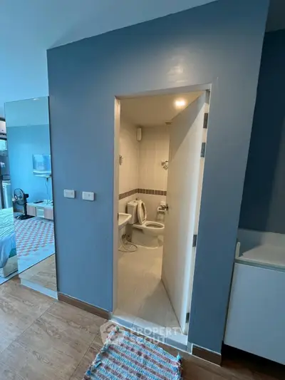 Compact bathroom with modern fixtures and adjacent bedroom view