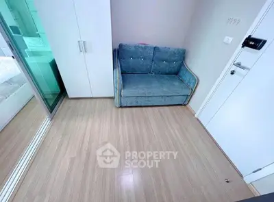 Cozy small living area with a compact sofa and modern flooring, perfect for urban living.
