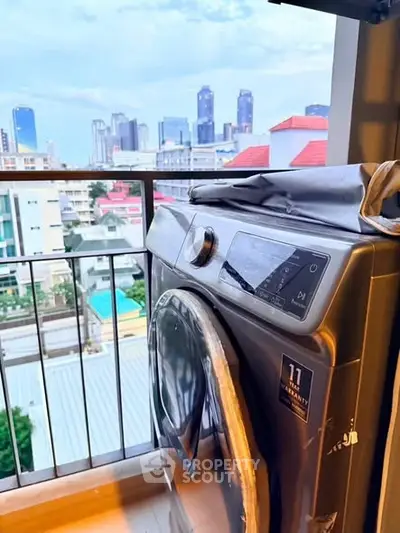 Modern washing machine on a balcony with stunning city skyline view, perfect for urban living.
