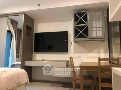 Modern studio apartment with wall-mounted TV and dining area