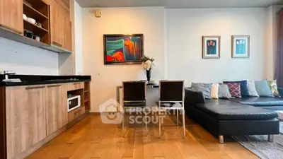 Modern living room with open kitchen, wooden flooring, and stylish decor.