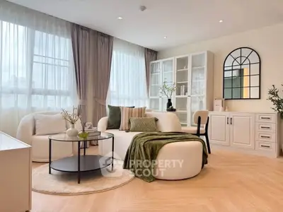 Elegant living room with modern furniture and large windows, featuring a cozy seating area and stylish decor.