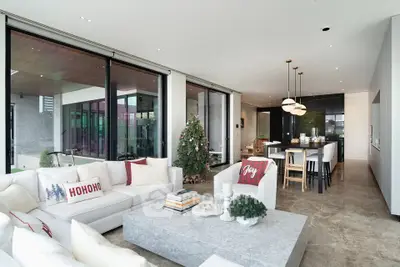 Luxurious open-plan living room with festive decor and modern kitchen in elegant home