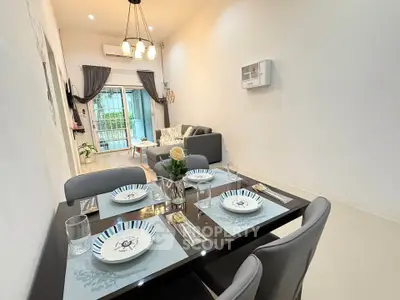 Modern dining and living area with elegant table setting and cozy seating.