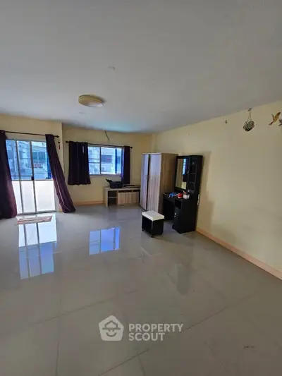 Spacious living room with large windows and modern furniture, perfect for natural light lovers.