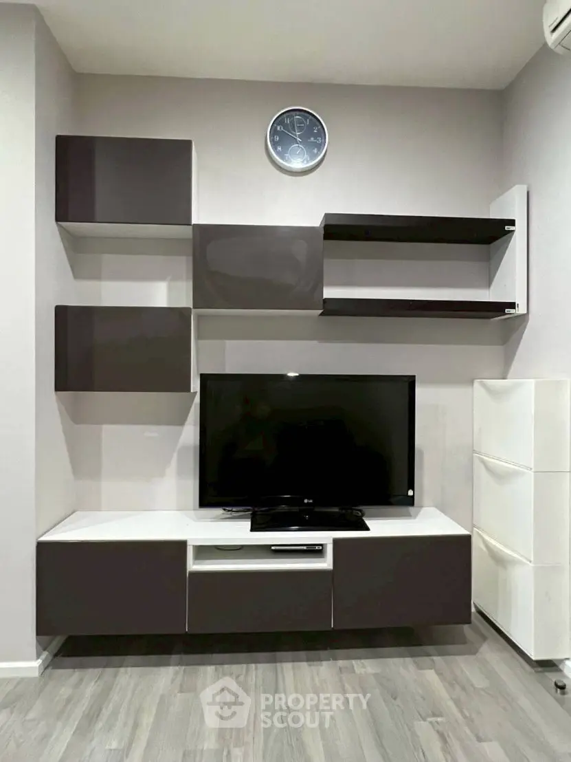Modern living room with sleek TV unit and wall-mounted shelves