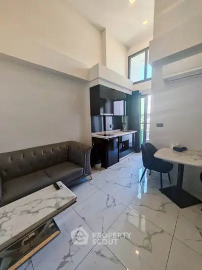 Modern living room with high ceilings, marble flooring, and stylish furniture in a contemporary apartment.