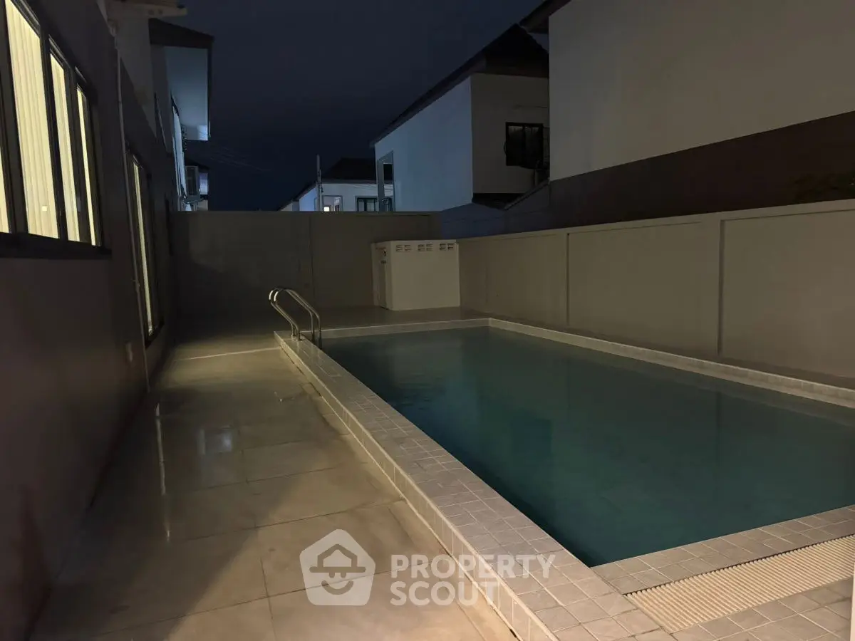 Modern residential pool area at night with sleek design and ambient lighting.
