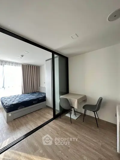 Modern studio apartment with glass partition and cozy dining area