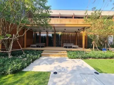 Luxurious garden area with modern wooden pergola and lush greenery, perfect for relaxation and outdoor gatherings.