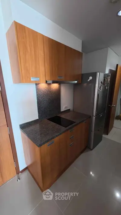 Modern kitchen with sleek wooden cabinets and stainless steel fridge